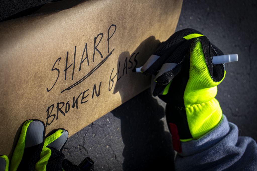 safely disposing of broken glass by labeling bag with a sharp broken glass warning