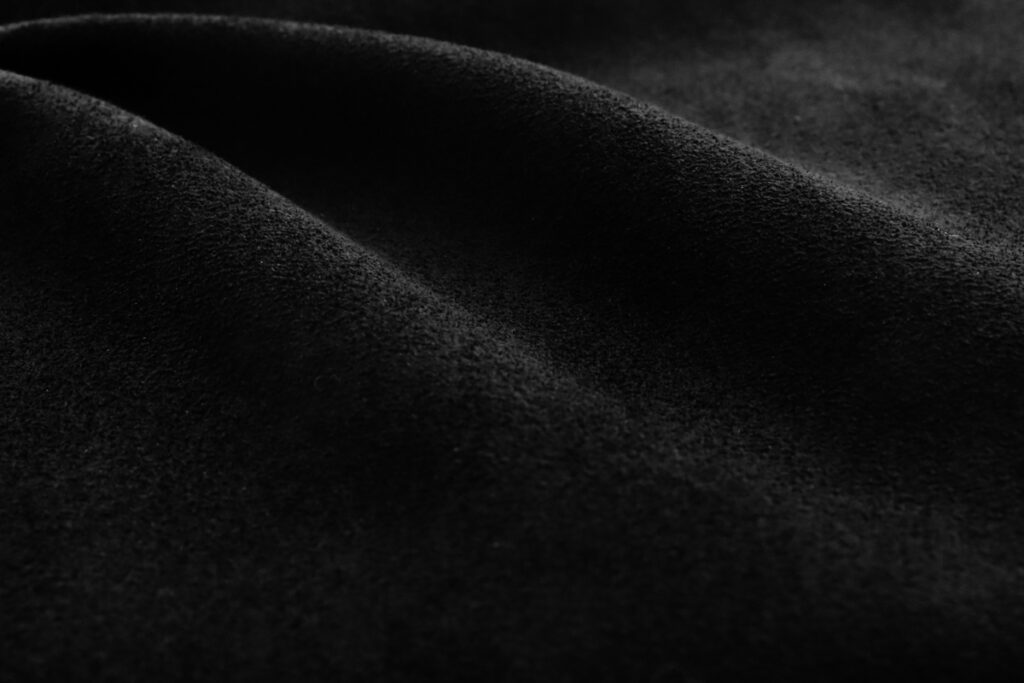 Close-up of a black suede glove material from AX Materials, showcasing its softness and comfort.