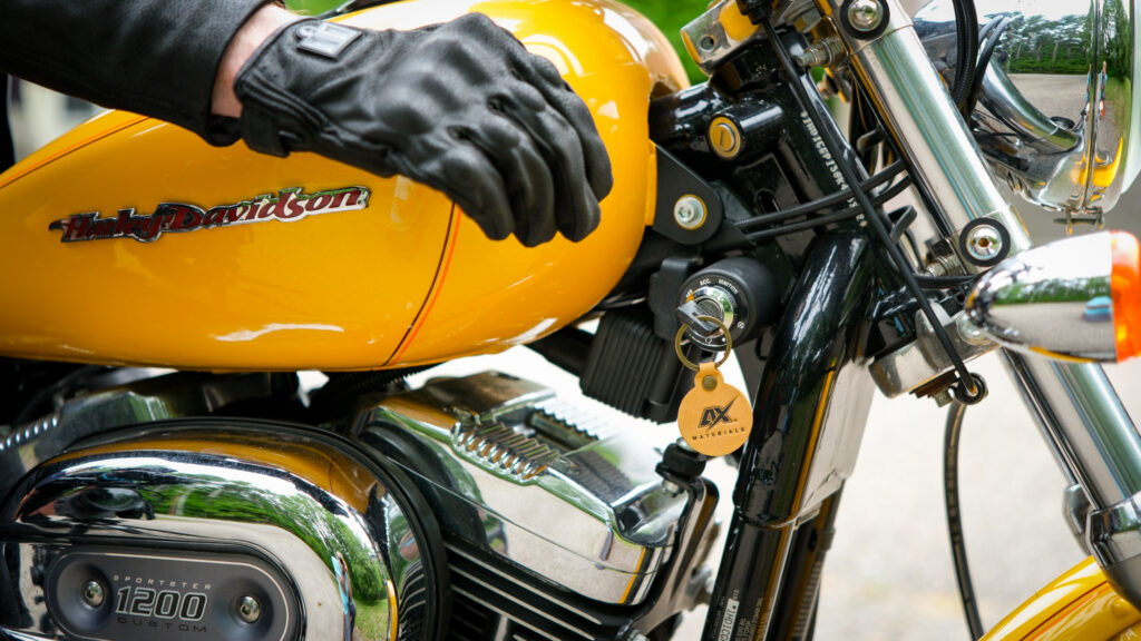 motorcyclist wearing motorcycle gloves made from AX Laredo leans hand on Harley Davidson bike